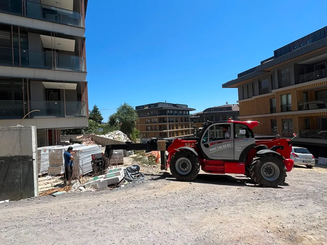 Manitou teleskopik yükleyici çatalla inşaat malzemesini üst kata taşırken