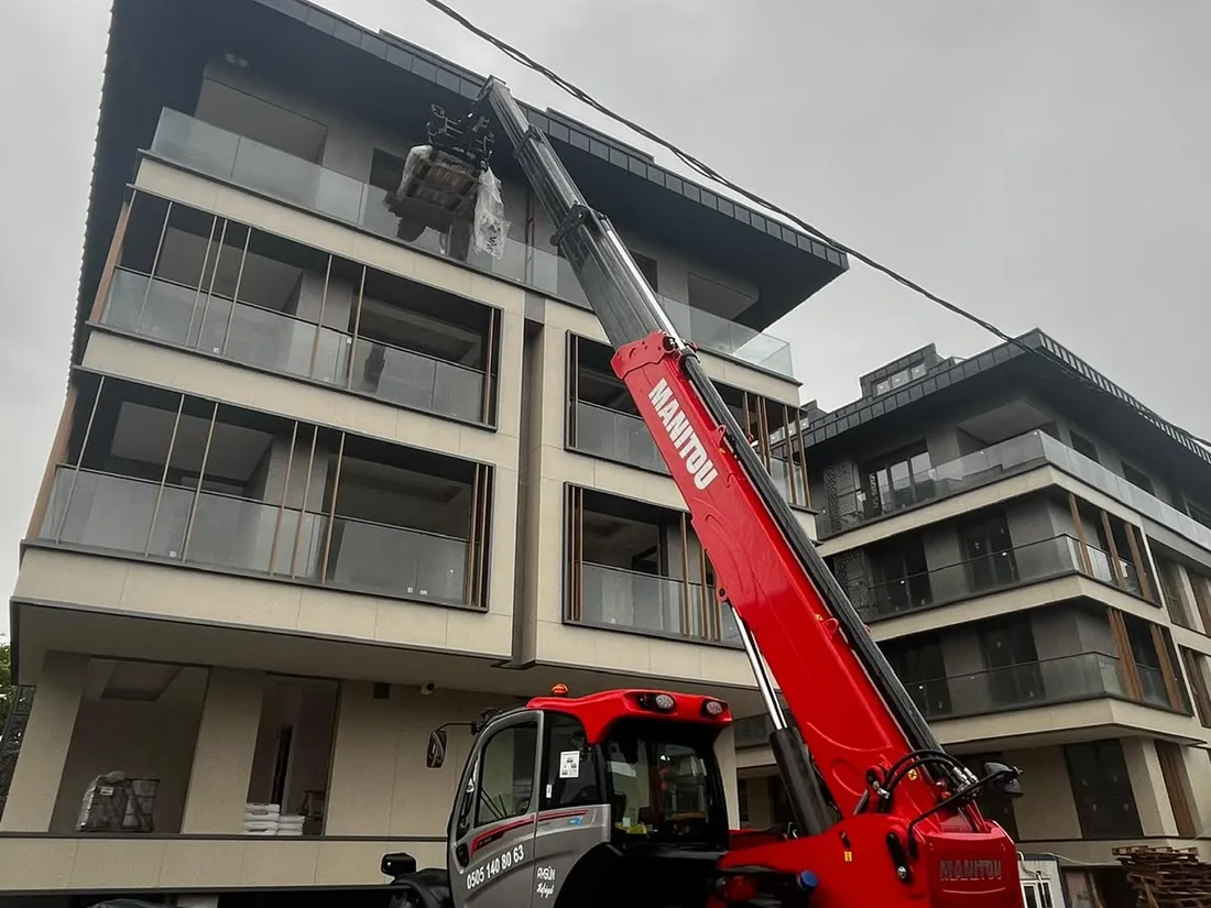 Manitou teleskopik yükleyici ile binanın çatı katına malzeme çıkarma